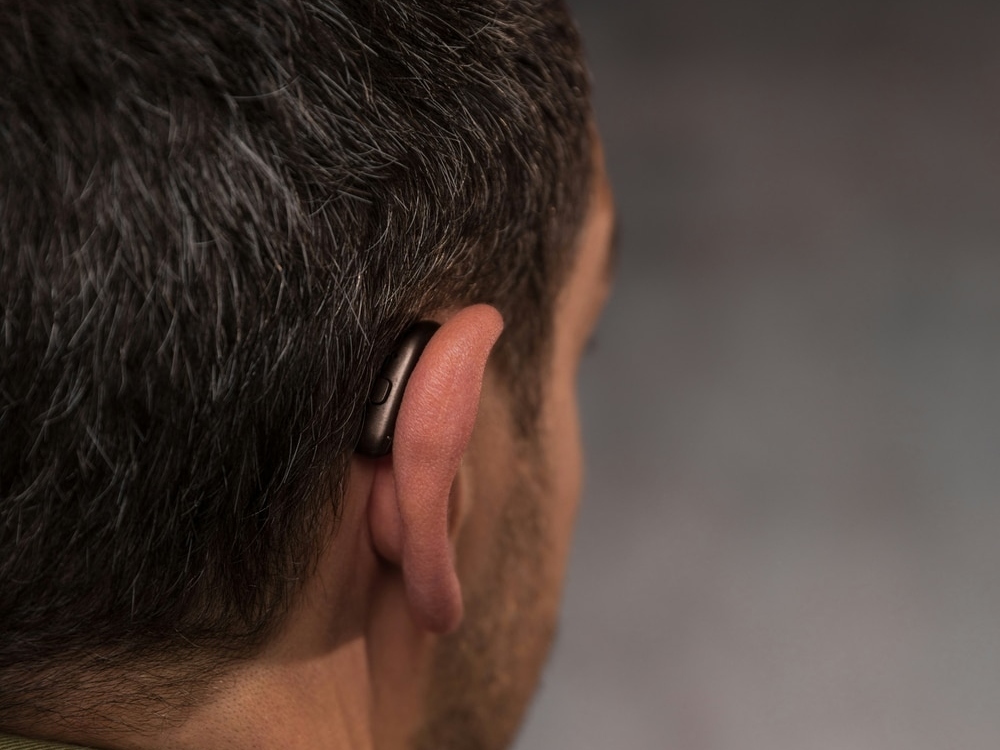 Doctor of Audiology programming a new hearing aid during a fitting at Advanced Hearing Technology in Naples, FL